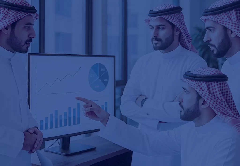 Colleagues reviewing business performance charts on a monitor